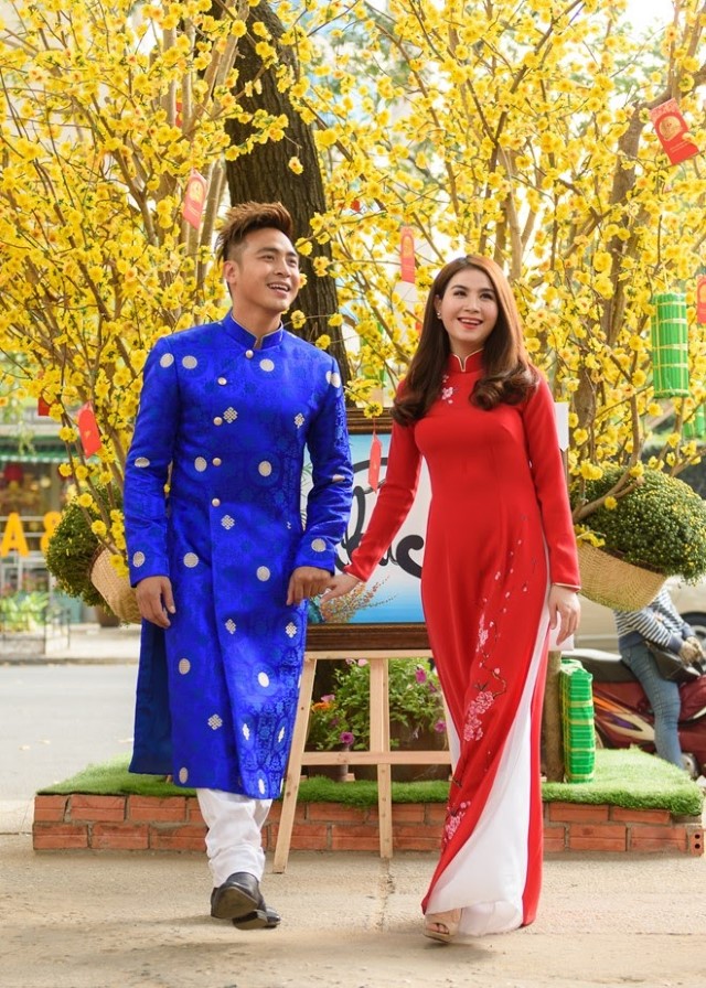 青いアオザイを着たベトナム人男性と赤いアオザイの女性