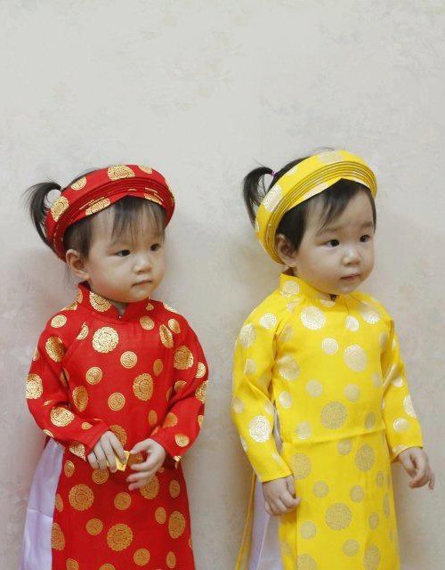 赤と黄色のアオザイを着たベトナム人の子供