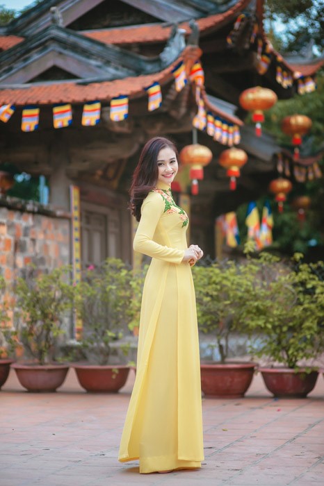 黄色いアオザイを着たベトナム人女性