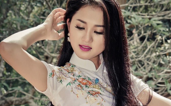 柄のある白いアオザイを着たベトナム人女性