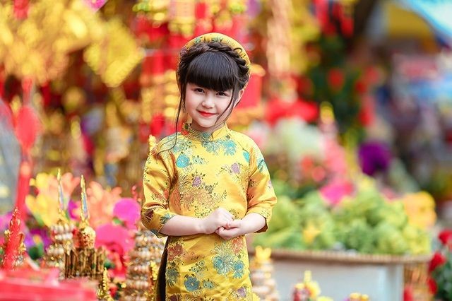 黄色いアオザイを着たベトナム人の子供