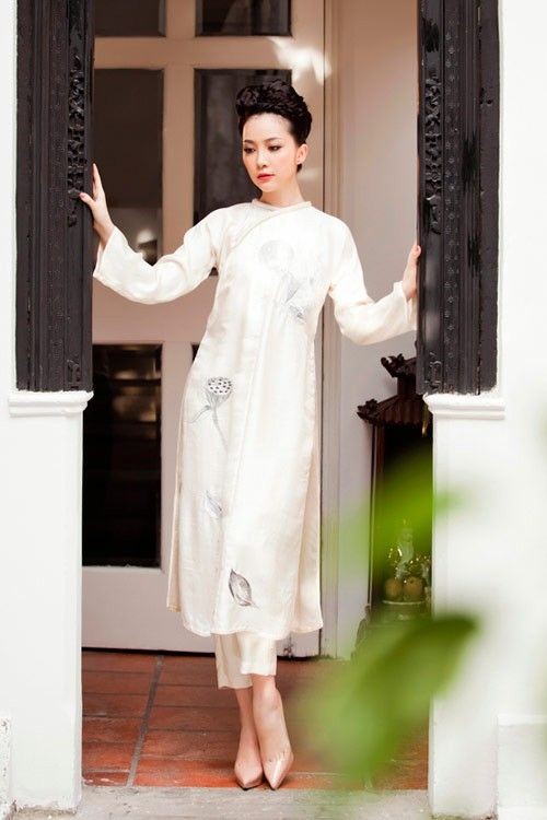柄の入った白いアオザイを着たベトナム人女性