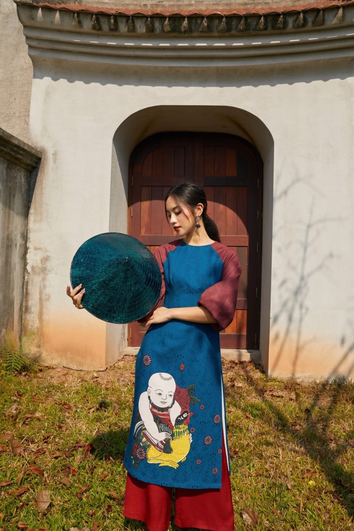 柄の入った青系のアオザイを着たベトナム人女性