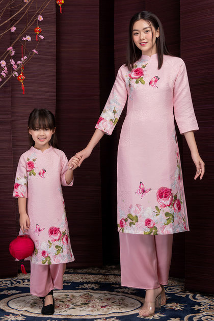 柄の入ったピンクのアオザイを着たベトナム人女性