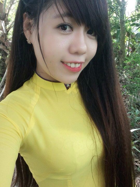 黄色いアオザイを着たベトナム人女性