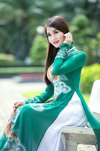 緑色のアオザイを着たベトナム人女性