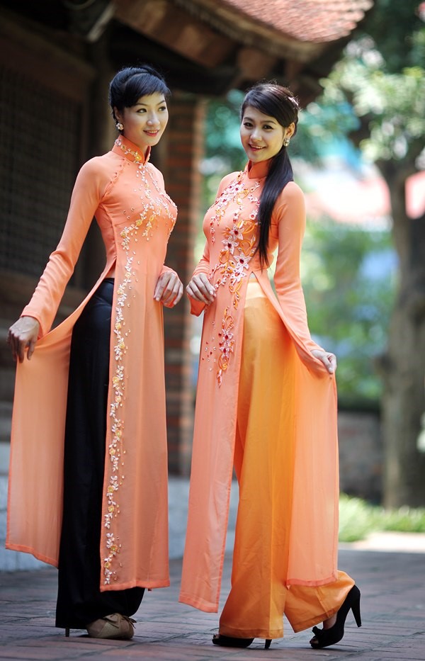 オレンジのアオザイを着ているベトナム人女性